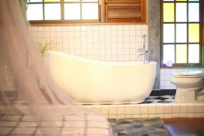 a bathroom with a white tub and a toilet at T-house Bkk - Max15 people with private swimming pool in Bangkok