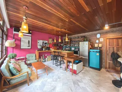 a kitchen and living room with pink walls at T-house Bkk - Max15 people with private swimming pool in Bangkok