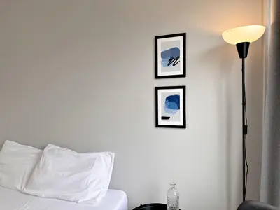 a bedroom with a bed and three framed pictures on the wall at Na Ekkamai Residence in Bangkok