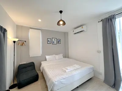 a small bedroom with a bed and a chair at Na Ekkamai Residence in Bangkok