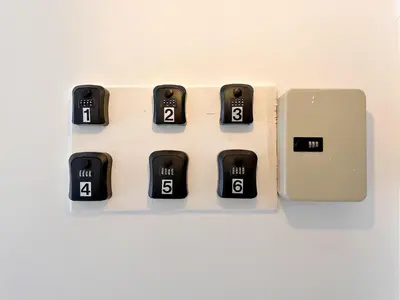 a row of black clocks on a white wall at Na Ekkamai Residence in Bangkok