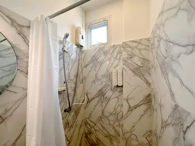 a bathroom with a shower and a shower curtain at Na Ekkamai Residence in Bangkok