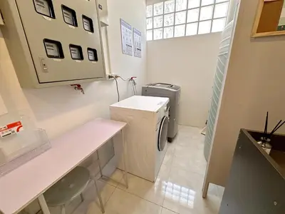 a small bathroom with a washer and dryer at Na Ekkamai Residence in Bangkok