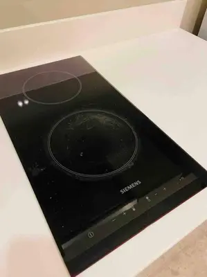 a black stove top on a white counter top at Luxury 1BR 300m BTS PhromPhong, Empo, EmQ, EmSphere, Rooftop Pool, Gym, Fast 500mbps wifi in Bangkok