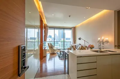 a kitchen with a sink and a living room at Luxury 1BR 300m BTS PhromPhong, Empo, EmQ, EmSphere, Rooftop Pool, Gym, Fast 500mbps wifi in Bangkok