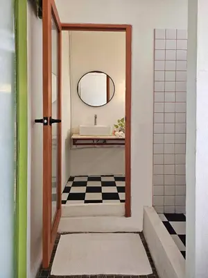 a bathroom with a door and a sink and a mirror at SANT Bangkok at Khaosan Road in Bangkok