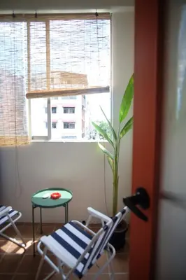 a room with two chairs and a plant and a window at SANT Bangkok at Khaosan Road in Bangkok