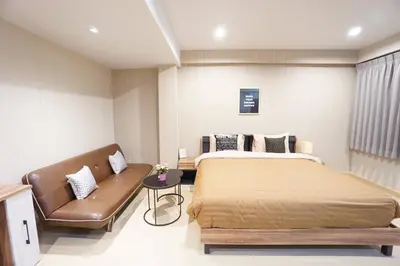 a bedroom with a bed and a couch at Maruay Living Apartment (Khaosan/Chinatown/Samyot MRT) in Bangkok