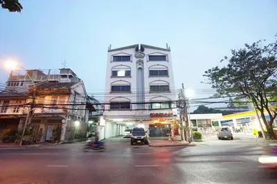 a tall white building with cars parked in front of it at Maruay Living Apartment (Khaosan/Chinatown/Samyot MRT) in Bangkok