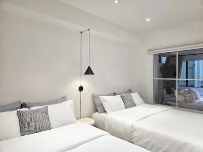 a bedroom with two beds and a couch at PB home 1 min to BTS Saladaeng & MRT Silom in Bang Rak
