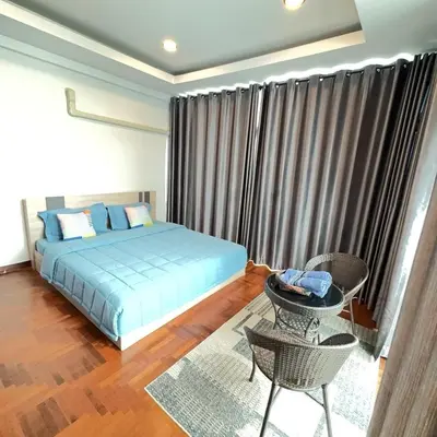 a bedroom with a bed and a table and a chair at Noc House in Bang Khlo