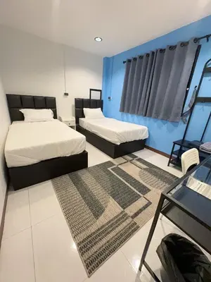 a bedroom with two beds and a blue wall at Noc House in Bang Khlo