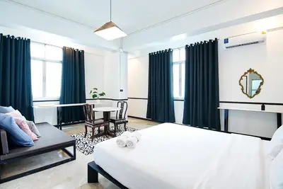 a bedroom with a bed and a table and chairs at The Character Yaowarat เดอะคาแลตเตอร์ เยาวราช in Khlong San