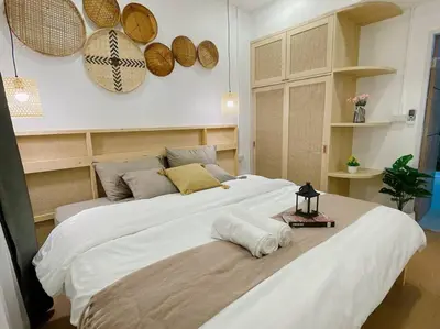 a large white bed in a bedroom with baskets on the wall at Relax Private terrace&cozy BR,near Grand palace in Bangkok