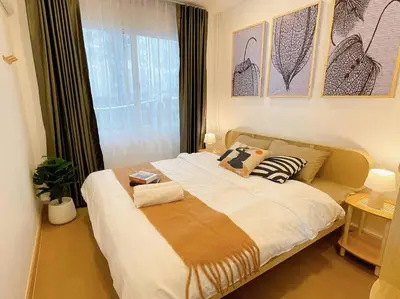 a bedroom with a large bed with a window at Relax Private terrace&cozy BR,near Grand palace in Bangkok