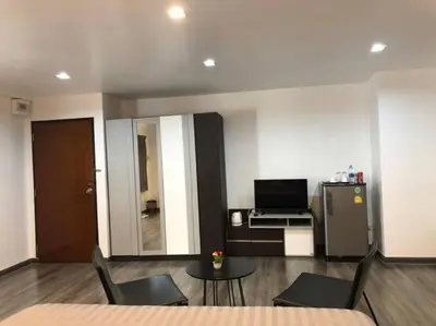 a living room with a table and a refrigerator at Maruay Living Apartment 401 (Khaosan/Chinatown/Samyot MRT) in Bangkok