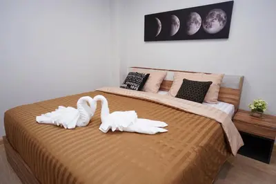two white swans are sitting on a bed at Maruay Living Apartment 510 (Khaosan/Chinatown/Samyot MRT) in Bangkok