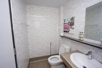 a white bathroom with a toilet and a sink at Maruay Living Apartment 510 (Khaosan/Chinatown/Samyot MRT) in Bangkok