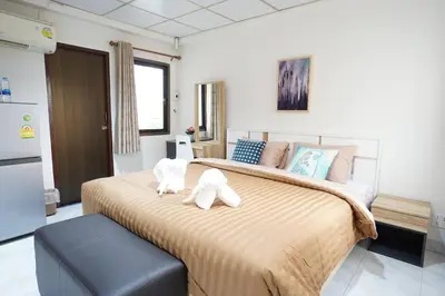 a bedroom with a large bed with two stuffed animals on it at Maruay Living Apartment 506 (Khaosan/Chinatown/Samyot MRT) in Bangkok
