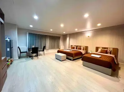 a hotel room with two beds and a table and chairs at Maruay Living Apartment 501 (Khaosan/Chinatown/Samyot MRT) in Bangkok