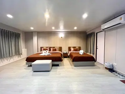 a bedroom with two beds and a flat screen tv at Maruay Living Apartment 501 (Khaosan/Chinatown/Samyot MRT) in Bangkok