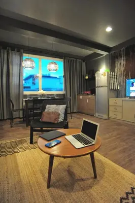 a living room with a laptop on a coffee table at Tuk Tuk House 250m from MRT Sirikit in Bangkok