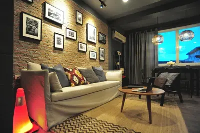a living room with a couch and a brick wall at Tuk Tuk House 250m from MRT Sirikit in Bangkok