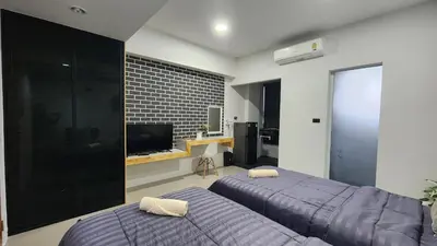 a bedroom with two beds and a television in it at Irich residence South Samrong 6 Kms BTS-Pu Chao in Samut Prakan