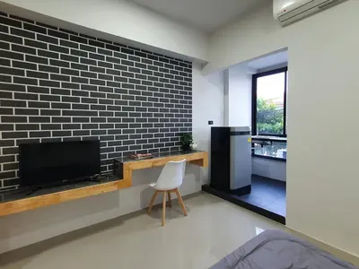 a living room with a tv and a brick wall at Irich residence South Samrong 6 Kms BTS-Pu Chao in Samut Prakan