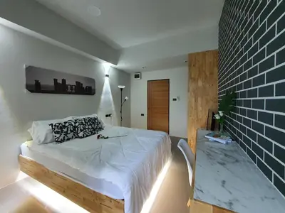 a bedroom with a bed and a brick wall at Irich residence South Samrong 6 Kms BTS-Pu Chao in Samut Prakan