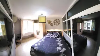 a bedroom with a large blue bed in a room at The Parkland Condominium in Bangkok