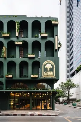 a green building with a sign on the side of it at Cher Hostel Bangkok in Bangkok