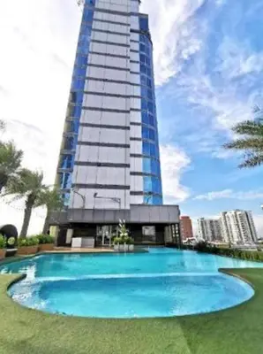 a large building with a large blue swimming pool at Capital O 75451 Podstel Hostel Bangkok in Bangkok