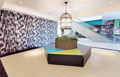 a lobby with a colorful bench and a staircase at Capital O 75451 Podstel Hostel Bangkok in Bangkok
