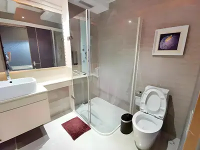 a bathroom with a shower and a toilet and a sink at Capital O 75451 Podstel Hostel Bangkok in Bangkok