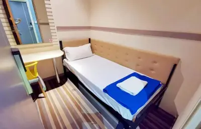 a small bed in a small room with a window at Capital O 75451 Podstel Hostel Bangkok in Bangkok