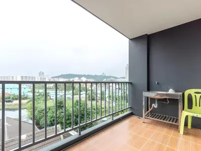 a room with a balcony with a desk and a yellow chair at Capital O 75451 Podstel Hostel Bangkok in Bangkok