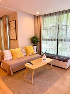 a living room with a couch and a table at Cozy Spacious 1BR 2Bed GardenView 500m BTS Thonglo, Samitivej, SKV49, Rooftop Pool, Fast 500mbps wifi in Bangkok