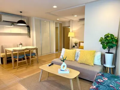 a living room with a couch and a table at Cozy Spacious 1BR 2Bed GardenView 500m BTS Thonglo, Samitivej, SKV49, Rooftop Pool, Fast 500mbps wifi in Bangkok