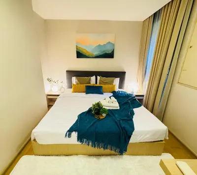 a bedroom with a large bed with a flower on it at Cozy Spacious 1BR 2Bed GardenView 500m BTS Thonglo, Samitivej, SKV49, Rooftop Pool, Fast 500mbps wifi in Bangkok