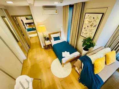 a small room with a bed and a couch at Cozy Spacious 1BR 2Bed GardenView 500m BTS Thonglo, Samitivej, SKV49, Rooftop Pool, Fast 500mbps wifi in Bangkok