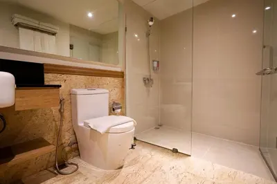 a bathroom with a toilet and a glass shower at The poshtel Bangkok By Benya BTS Phayathai in Bangkok