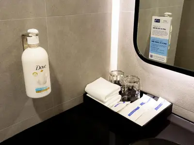 a bottle of soap on a shelf in a bathroom at Holiday Inn Express & Suites Bangkok Central Pier by IHG in Bangkok