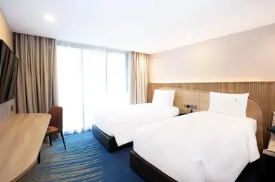 a hotel room with two beds and a window at Holiday Inn Express & Suites Bangkok Central Pier by IHG in Bangkok