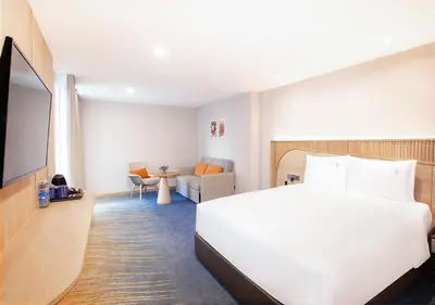 a hotel room with a bed and a tv at Holiday Inn Express & Suites Bangkok Central Pier by IHG in Bangkok