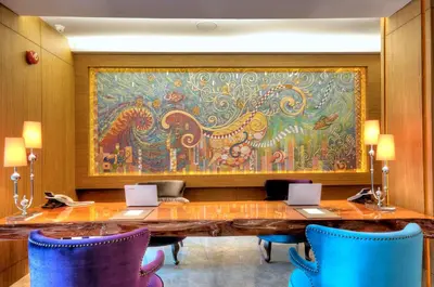 a large painting of an elephant on a wall with chairs at One One Bangkok in Bangkok