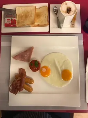a plate of breakfast food with eggs bacon and toast at One One Bangkok in Bangkok
