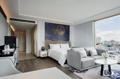 a hotel room with a bed and a couch at Grande Centre Point Surawong Bangkok in Bangkok