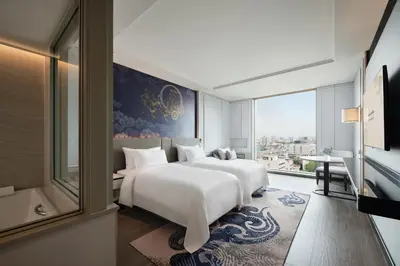a bedroom with a large white bed and a window at Grande Centre Point Surawong Bangkok in Bangkok