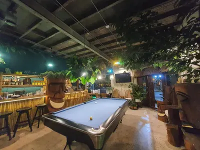 a pool table in a room with a bar at Motu Bangkok in Bangkok